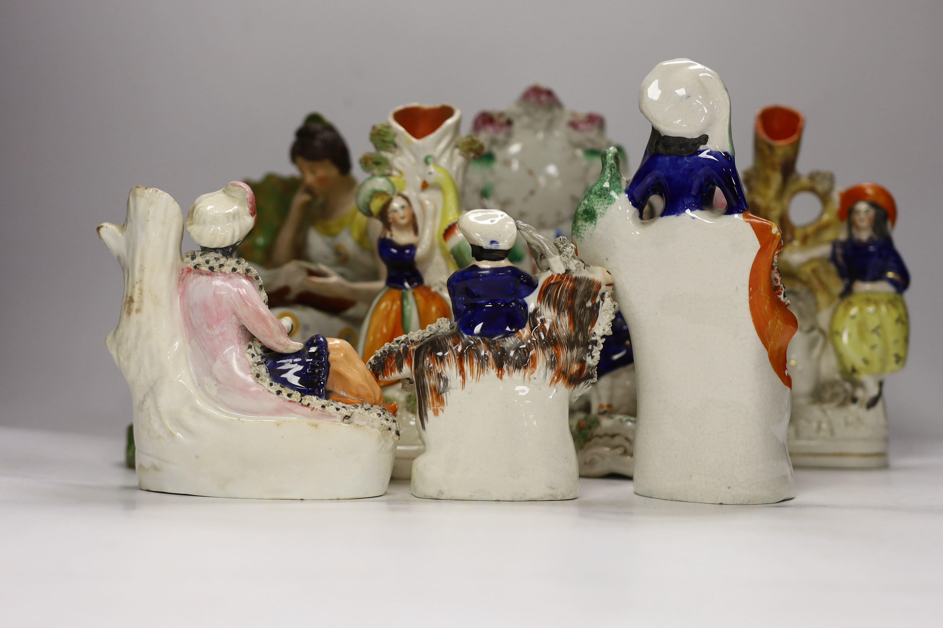 An early 19th century Staffordshire pearlware figure of a seated lady and seven mid 19th century Staffordshire pottery figures
